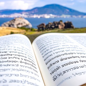 Open book with scenic landscape background.