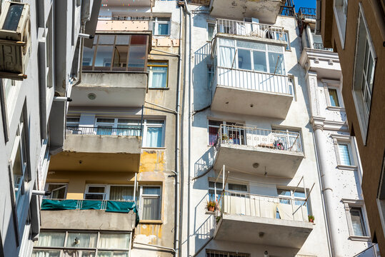 An old building with many balconies bathed in bright sunlight. The concept of old housing.