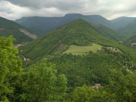 Paesaggio montano ricoperto da fitta vegetazione, con una collina triangolare che emerge tra le valli circostanti. Atmosfera naturale, verde e incontaminata, tipica dei rilievi dell&rsquo;Italia centrale