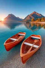 Fototapeta premium Two wooden rowboats on a calm alpine lake at sunrise with mountain reflections and peaceful shore