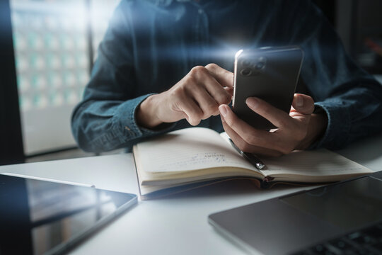 Businessman using mobile phone while working by connecting technology and synchronizing between devices