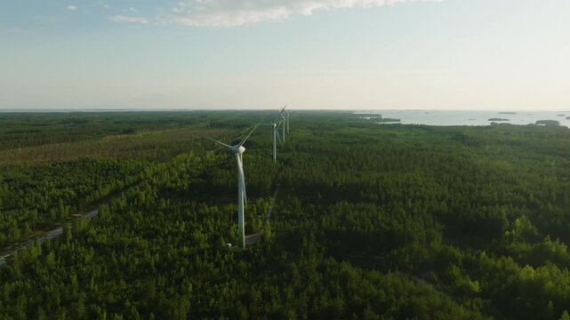 Aerial tracking shot of Sustainable energy: Wind power power generators standing in Hanko