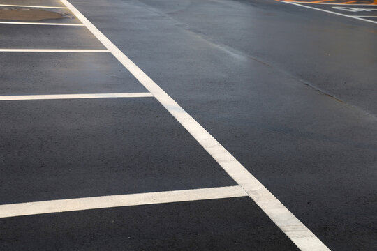 White lines on empty asphalt parking lot surface