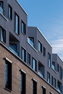 Brick facade rises beside a residential apartment building in Loren where balcony detail and urban architecture sharpen the Oslo, Norway view