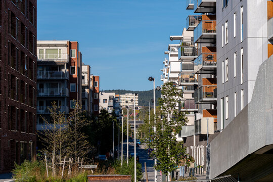 Urban street opens between residential apartment building blocks in Loren as balcony edges and facade lines shape architecture in Oslo, Norway