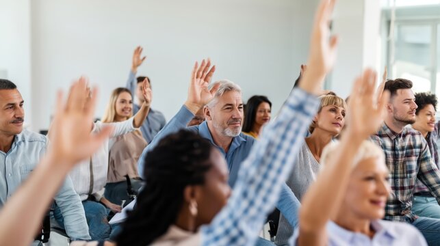 Engaged audience raising hands during corporate training session in a bright conference room.