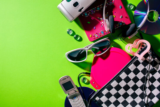 Retro millennium aesthetic composition with flip phone and checkered bag