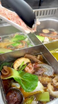 Cooking Pork Paste in a Boiling Thai Hot Pot with Vegetables