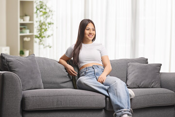Fototapeta premium Young woman sitting on a sofa