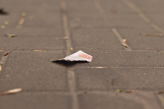 A torn piece of a five-thousand ruble banknote lying on a tiled street in the city.