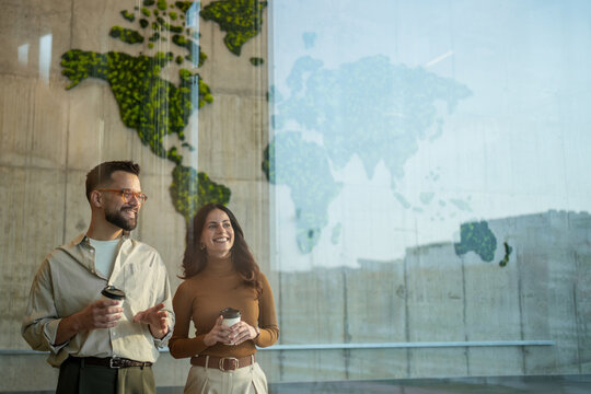 Business partners discussing global strategy reflecting world map