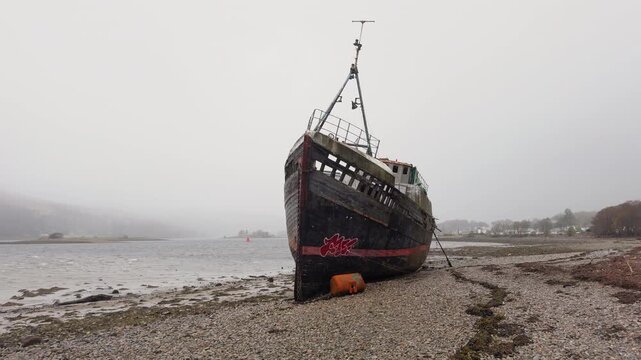 Slow pan camera shot of Corpach Wreck, Loch Linnhe, Scottish Highlands, overcast day, decaying rust vessel, Scotland