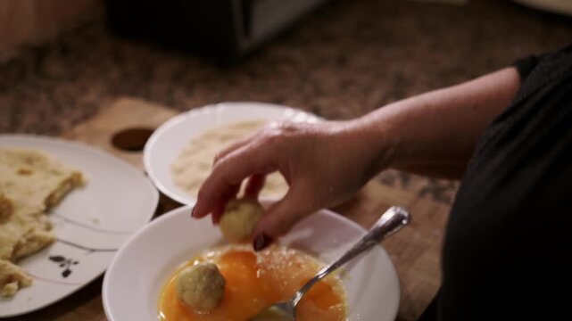 Spanish Croquettes Homemade Preparation. Woman Breading Traditional Bechamel Croquetas in Kitchen.