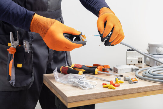 Close-up of a technician connecting wires. Electrician working.