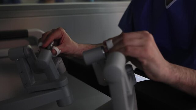 Robotic surgery. 4k video Close-up of a surgeon's hands using the specialized controllers of the robotic system console to perform minimal invasive cancer surgery.