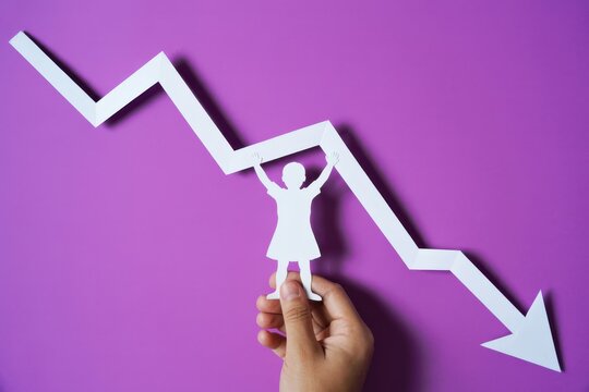 Person celebrates declining graph trend with raised arms