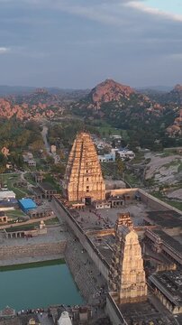 Aerial 4K drone footage of Hampi in Karnataka India. Cinematic bird's eye view of ancient ruins and boulder-strewn landscape with temple