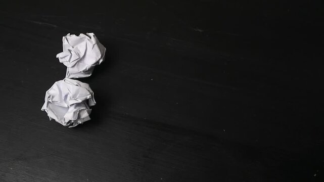 Crumpled White Paper Balls Appearing on a Black Wooden Background