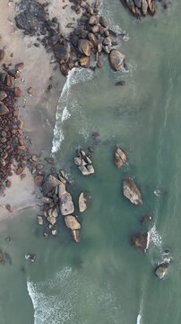 Aerial 4K drone footage of Palolem beach in Goa India. Stunning bird's eye view of the crescent-shaped bay with calm turquoise waters and lush palm-lined shores.