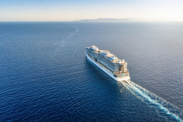 High aerial view of a cruise ship sailing over blue ocean into the sunset with copy space as a concept for travel and vacation © moofushi