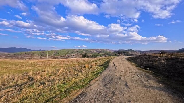 Dirt Road Trail Through Hills in Bulgarian Countryside at Sunset, Scenic Nature Landscape With Blue Sky and Rural Path, Mountain Meadow Panorama in Bulgaria, Outdoor Travel Destination, Peaceful