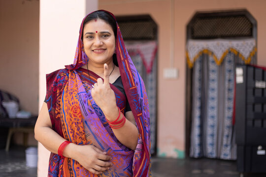 Indian  mid aged rural woman standing in and showing their finger marked with blue ink after casting vote. Election in india. Indian Ethnicity, Lifestyle, Portrait, Middle Class woman in India.
