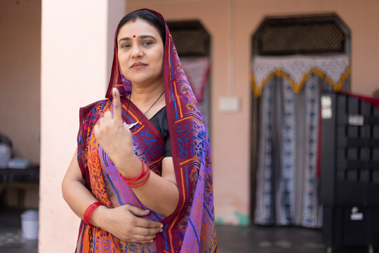 Indian  mid aged rural woman standing in and showing their finger marked with blue ink after casting vote. Election in india. Indian Ethnicity, Lifestyle, Portrait, Middle Class woman in India.