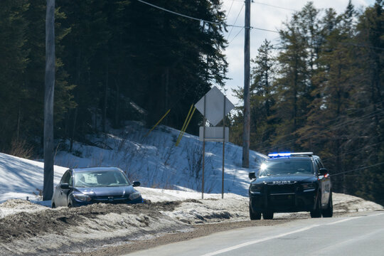 Canada, 11 April 2026 : Police vehicle responds to a Honda car off the road in a snowy ditch