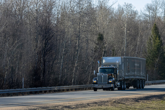 Quebec, Canada, 24 April 2026 : A Western Star semi-truck with an RBD Trans trailer drives on a highway past bare trees.