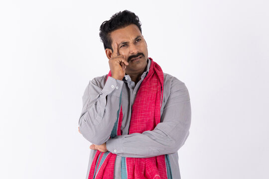 Portrait of a young indian deep thinking sad and discouraged farmer man lost deeply against white studio background