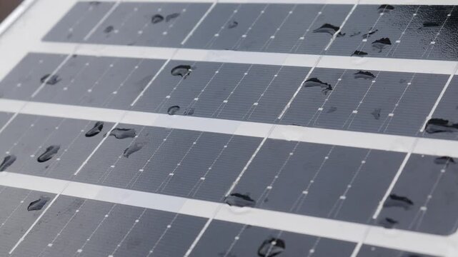 Closeup solar panel surface with water rain droplets showing photovoltaic cell grid pattern renewable clean energy technology