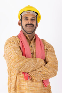 Portrait of a indian man labour worker arm crossed and wearing safety uniform and yellow engineer cap. worker looking at camera isolated on studio grey background