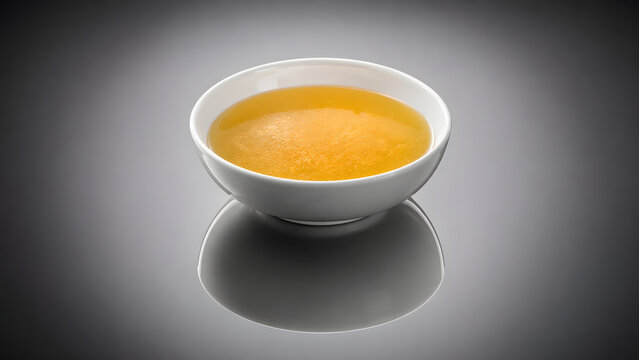 High contrast chicken essence soup reflection composition creates dramatic premium food photography aesthetic in studio setting