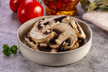 Fototapeta premium Dried mushrooms in a bowl with tomatoes and cooking ingredients