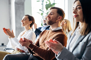 Obraz premium Business professionals in a conference audience clapping hands, showing appreciation and giving applause to a speaker