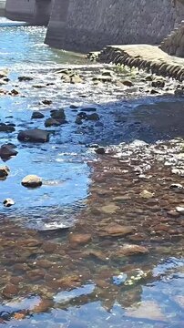 Glistening water flowing through rocks in a stream canal, Rural Drainage, Wet Waterway, Rural Conservation
