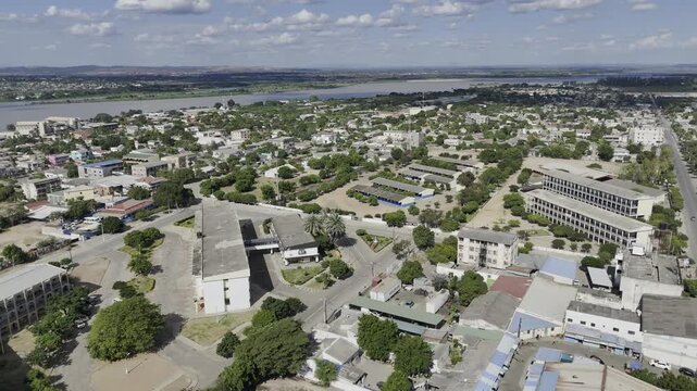 Drone orbits to right around two secondary schools downtown on a sunny day in Tete, Mozambique