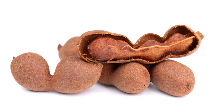 Fresh tamarind pods and open shell with pulp isolated on white background.