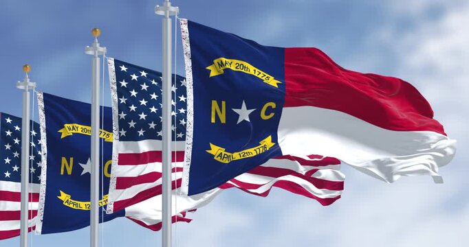 North Carolina state flags waving with american flag. Seamless 3d render animation. Slow motion loop. Selective focus