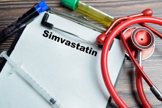 Concept of simvastatin write on clipboard isolated on Wooden Table.