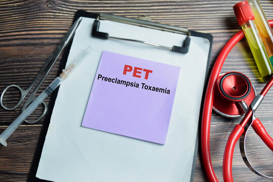 Concept of PET - Preeclampsia Toxaemia write on sticky notes isolated on Wooden Table. A multi-system disorder during pregnancy including high blood pressure and proteinuria