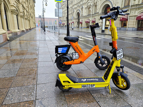 Electric scooter stands on wet street in moscow russia