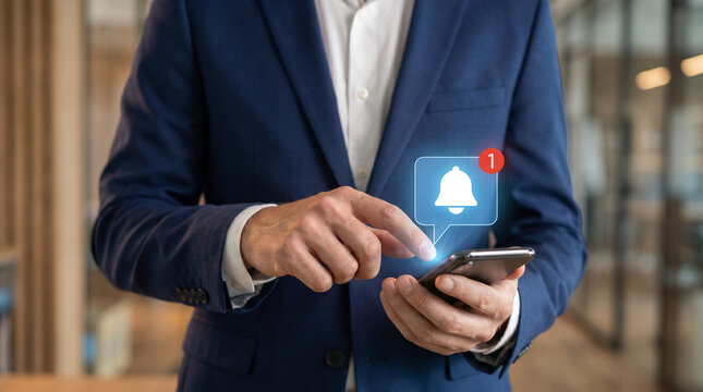 Mobile business notification concept with professional using smartphone and glowing bell icon