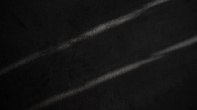 light creating parallel bright streaks on a dark textured surface, Still shot