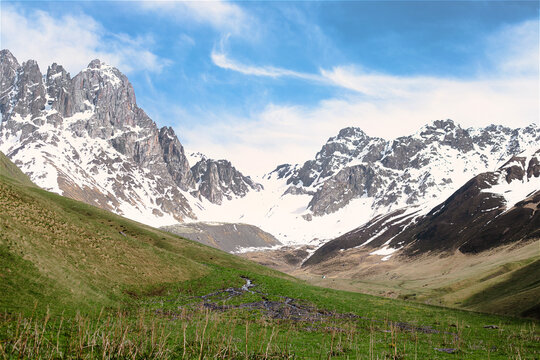 Caucasian mountain landscape in Juta with snow peaks and lush green meadows