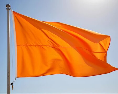 Orange Flag Waving Against Blue Sky