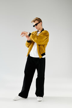 Fashion forward young man showcases style in a striking outfit against a simple backdrop