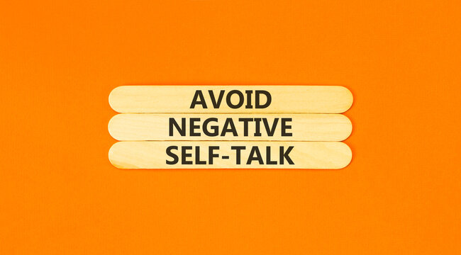 Avoid negative self-talk symbol. Concept words Avoid negative self-talk on beautiful wooden sticks. Beautiful orange background. Business psychology avoid negative self-talk concept. Copy space.
