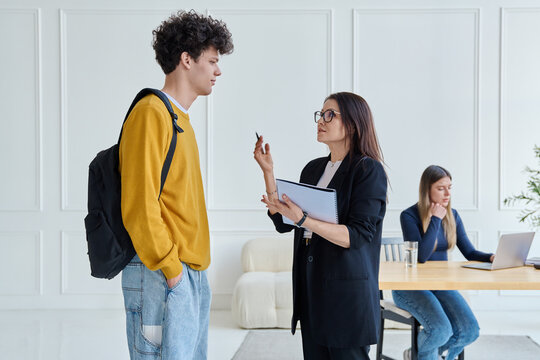 Female teacher and male university student together inside the classroom
