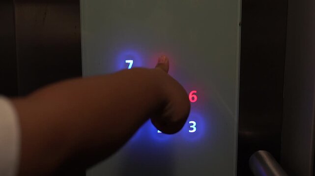 Someone is pressing the elevator button to go up the building.